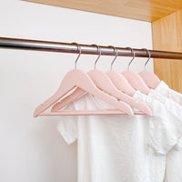 kids clothes hung on pink kids wooden hangers, white shirt and blue shirt on children pink wood hangers
