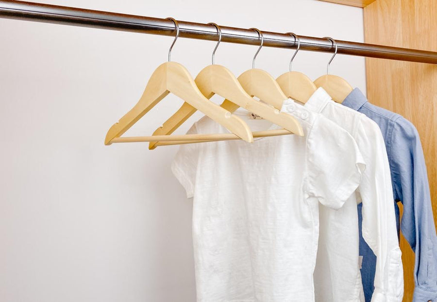 kids clothes hung on natural kids wooden hangers, white shirt and blue shirt on children natural  wood hangers