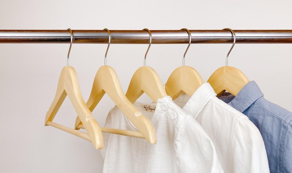 kids clothes hung on natural kids wooden hangers, white shirt and blue shirt on children natural wood hangers
